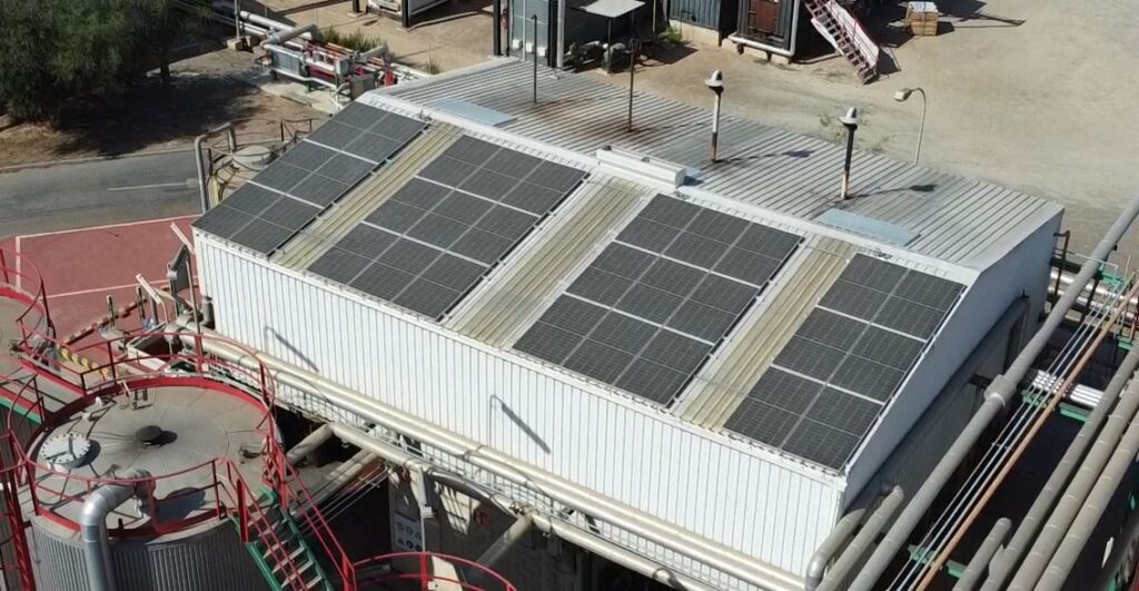 Vista aérea de nave industrial con campo fotovoltaico en cubierta Vista aérea de nave industrial con campo fotovoltaico en cubierta