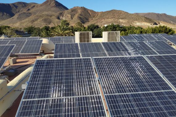 Filas de módulos fotovoltaicos sobre cubierta con paisaje natural