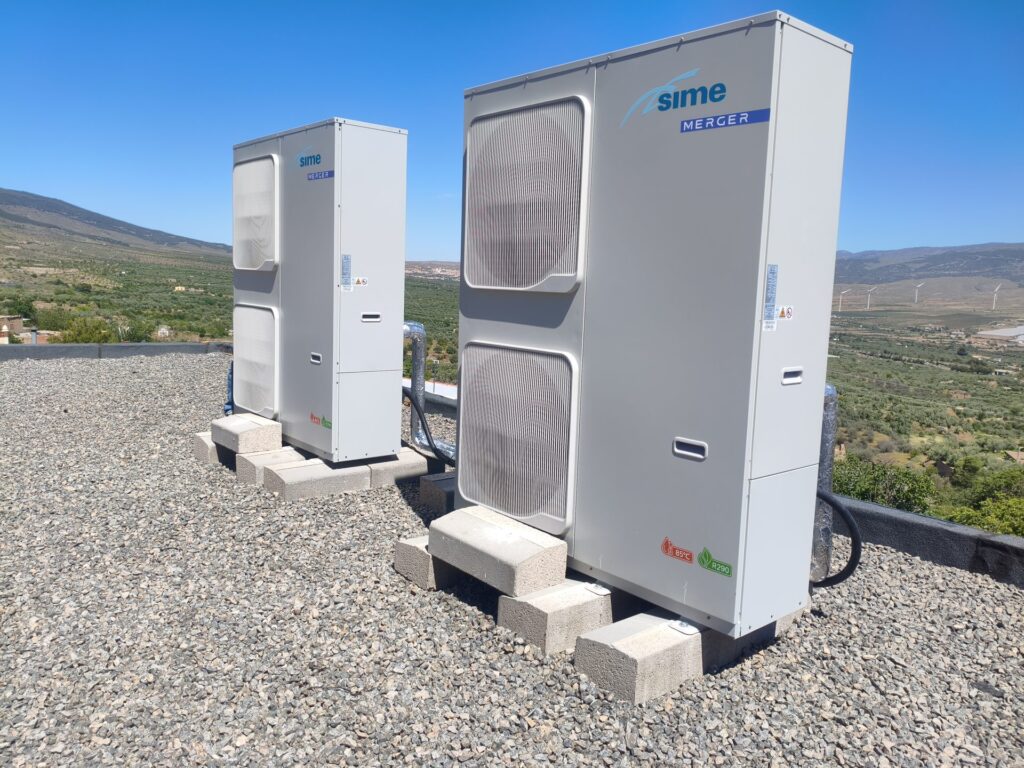 Bombas de calor de aerotermia instaladas en la cubierta del colegio con las montañas al fondo Bombas de calor de aerotermia instaladas en la cubierta del colegio con las montañas al fondo