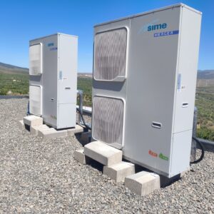 Bombas de calor de aerotermia instaladas en la cubierta del colegio con las montañas al fondo