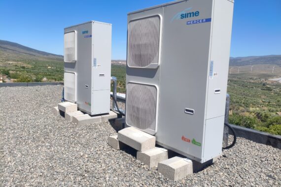Bombas de calor de aerotermia instaladas en la cubierta del colegio con las montañas al fondo Bombas de calor de aerotermia instaladas en la cubierta del colegio con las montañas al fondo