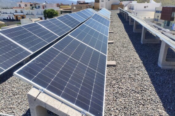 Filas de módulos fotovoltaicos sobre cubierta de grava del centro educativo Filas de módulos fotovoltaicos sobre cubierta de grava del centro educativo